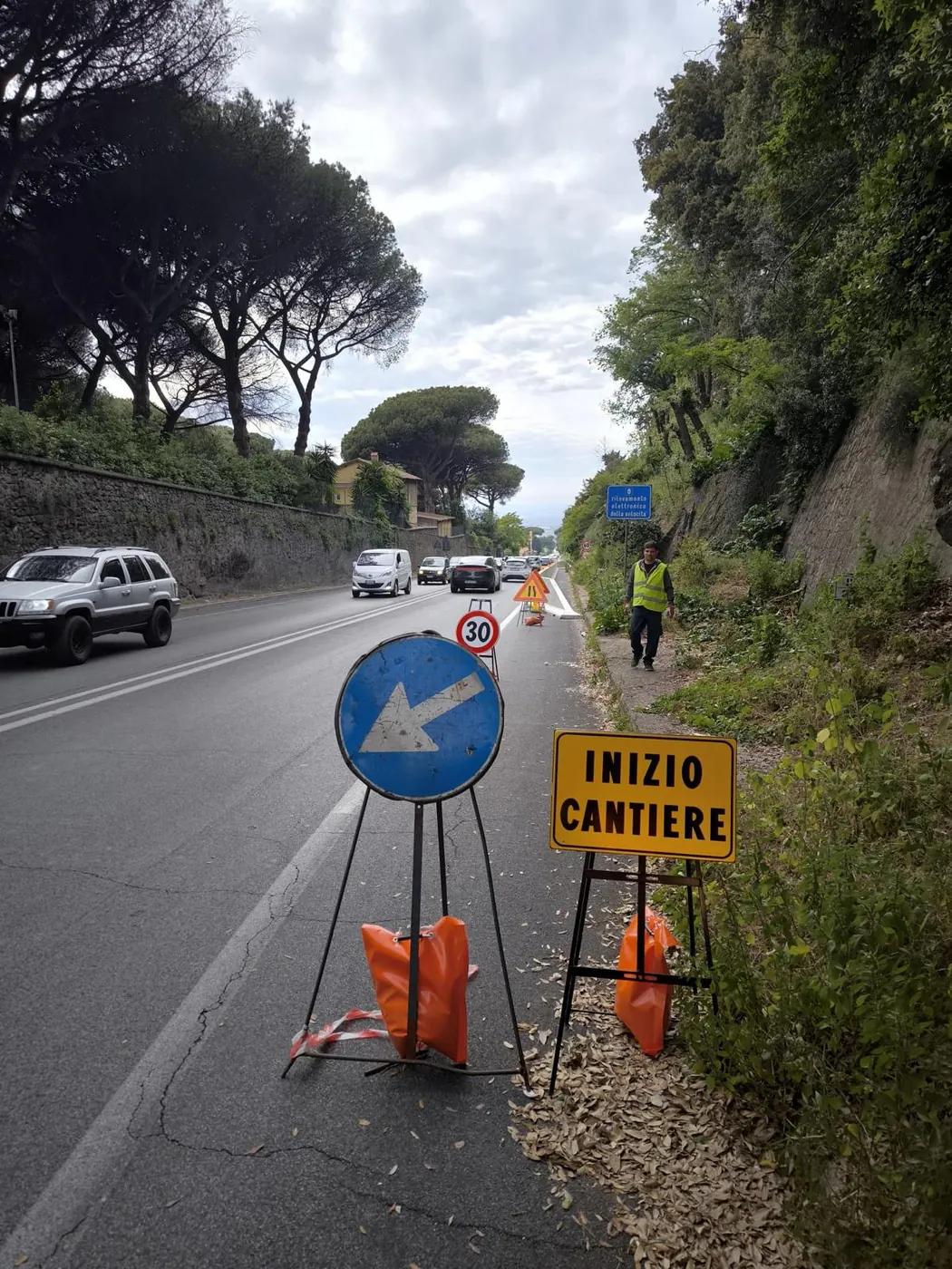 Cantiere stradale con segnaletica e operatore con gilet ad alta visibilità